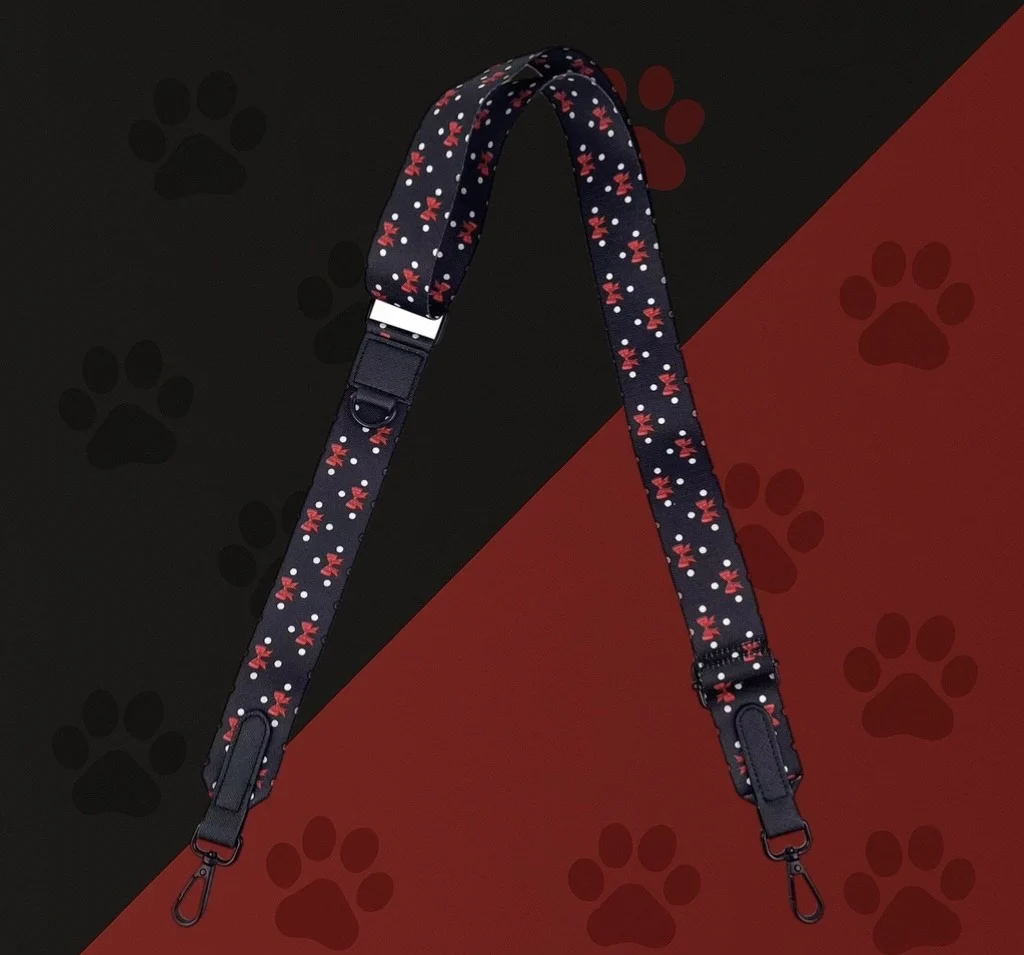 Bandoulière sacoche Woofty noir à pois et nœuds rouges, réglable, mousquetons métal noir.